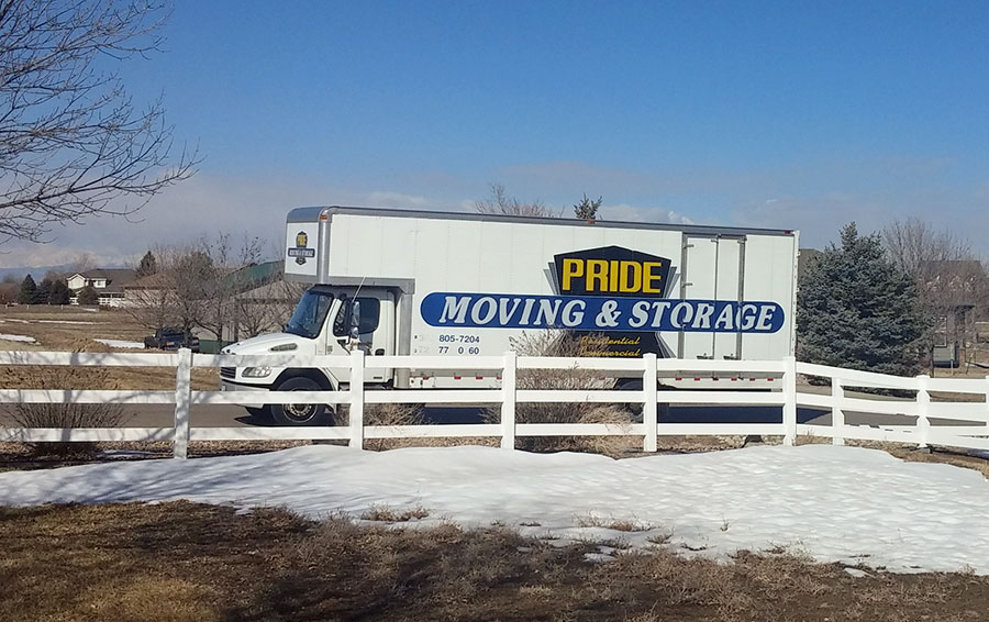 Pride Moving & Storage truck in front of a house